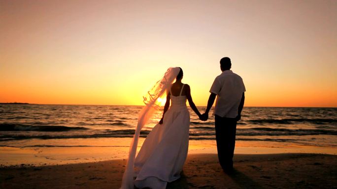 海边的新婚夫妇浪漫情侣海滨日出沙滩漫步