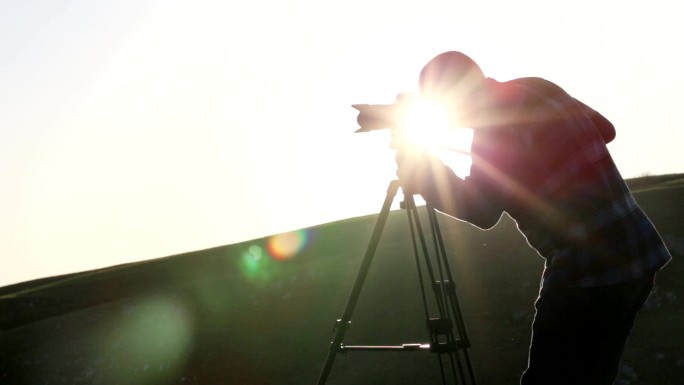 摄影师在山顶用相机和三脚架拍摄