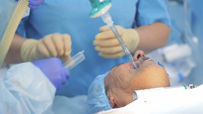 医生在进行手术时将管子插入病人的嘴里