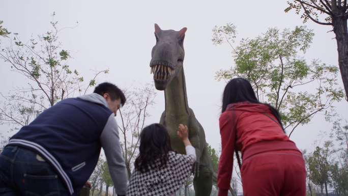 父母带孩子在恐龙主题公园游玩