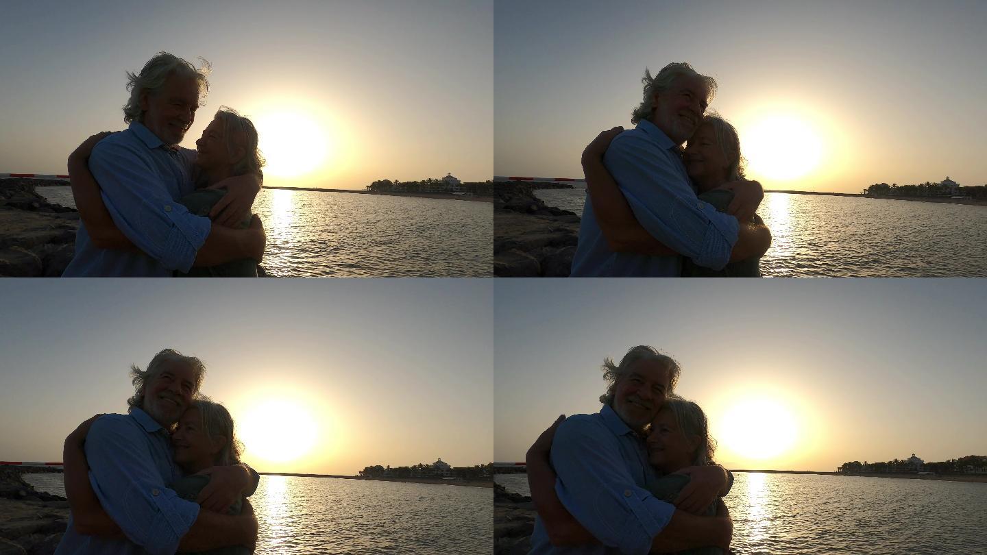 海边拥抱的老人老夫老妻夕阳黄昏傍晚