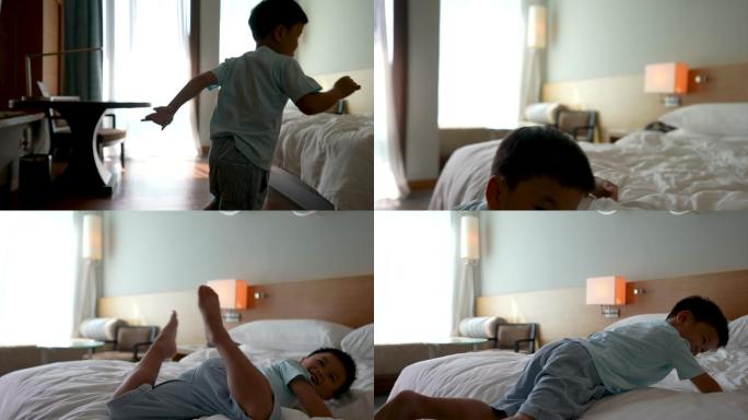 小孩跳上酒店的卧室的床。