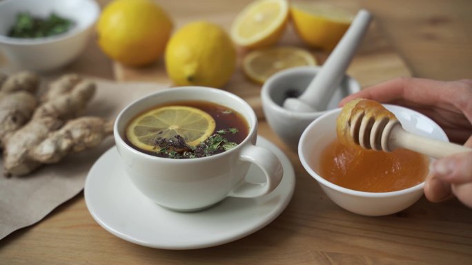 在一杯柠檬热茶中加入一茶匙蜂蜜。