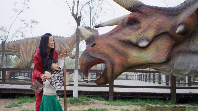 父母带孩子在恐龙主题公园游玩