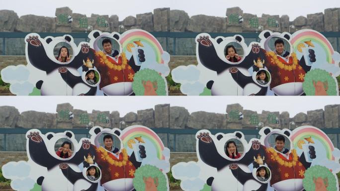 父母和孩子在动物园熊猫馆拍合影