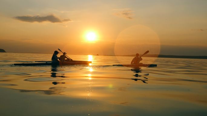 日落时划桨的人正在划独木舟