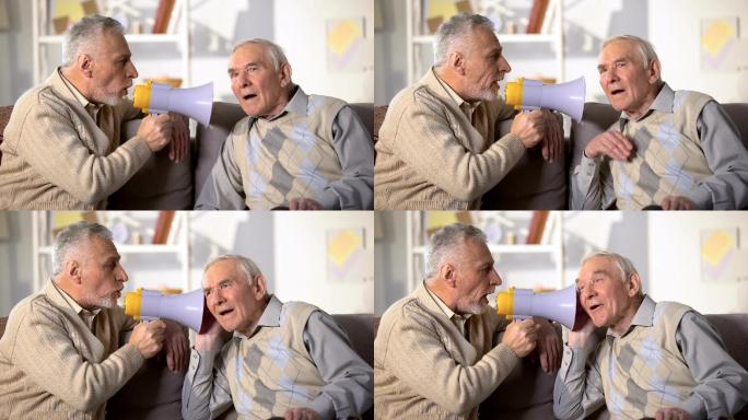 老年男性用扩音器与失聪的老朋友交谈