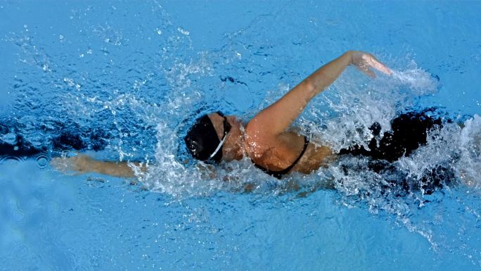 一名年轻女子在游泳池自由泳的超慢动作