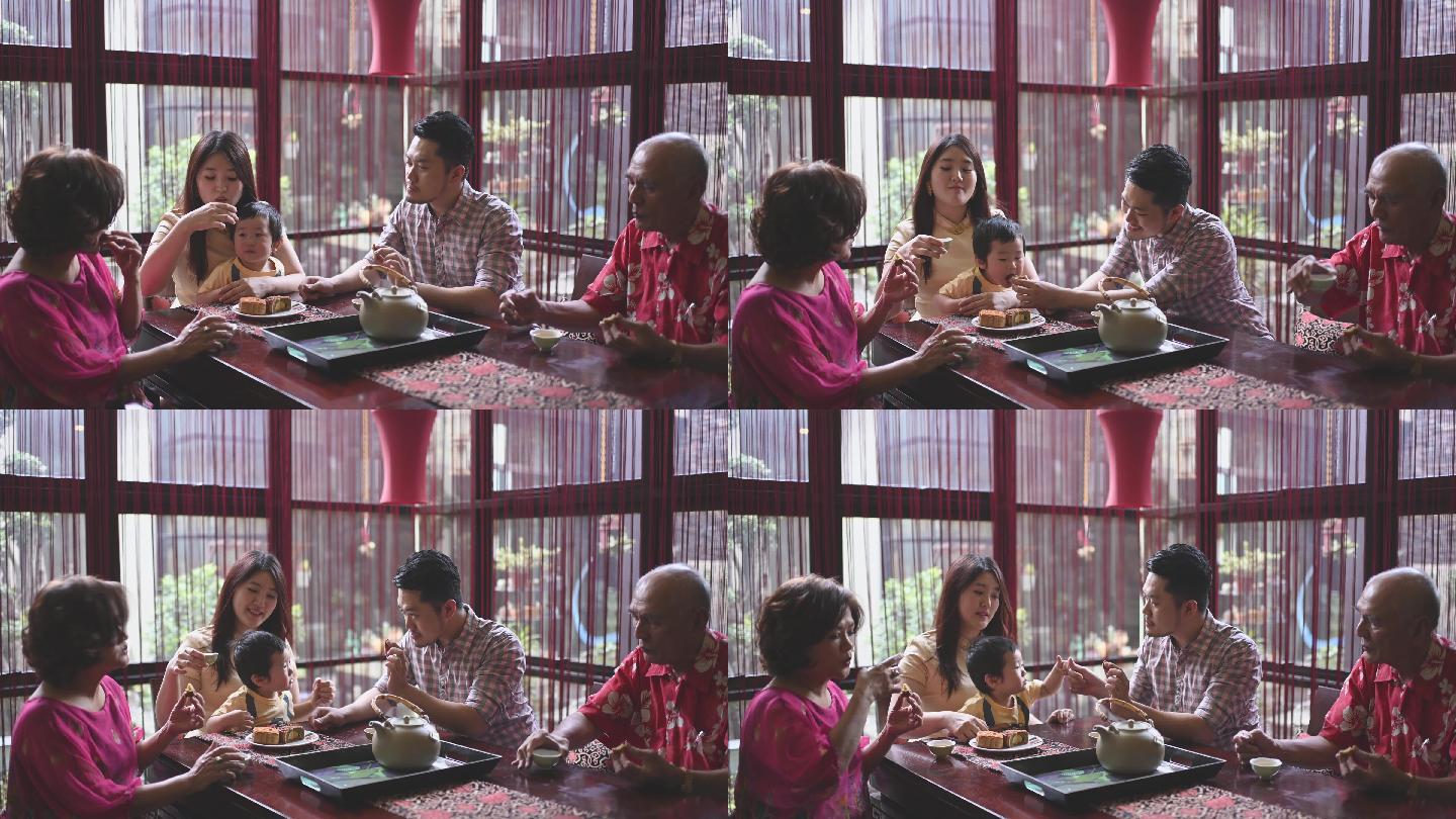 一家人在家里享用传统的中秋月饼和中国茶