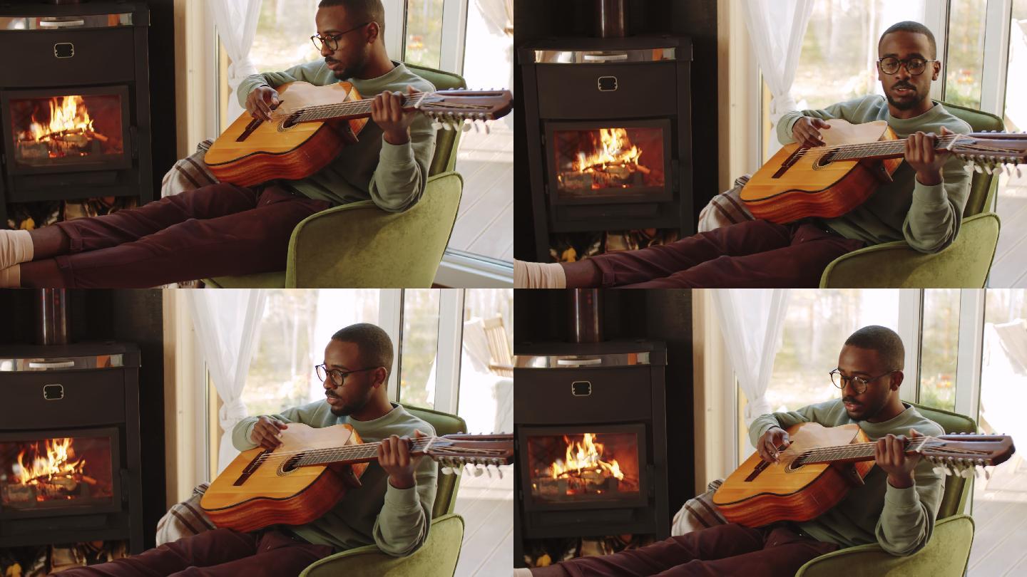 美国黑人男子在家壁炉旁弹吉他