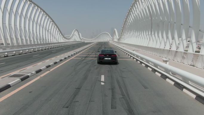 黑色的车正行驶在迪拜的梅丹桥上。