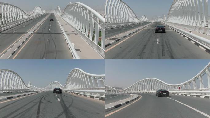 黑色的车正行驶在迪拜的梅丹桥上。