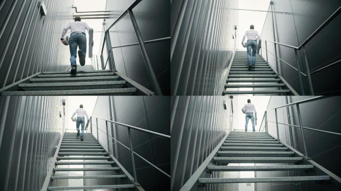 工程师在工厂钢制走道的楼梯上奔跑