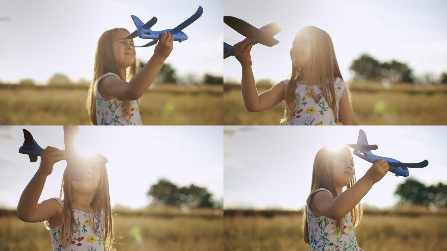 美丽的小女孩在草地上玩她的飞机模型