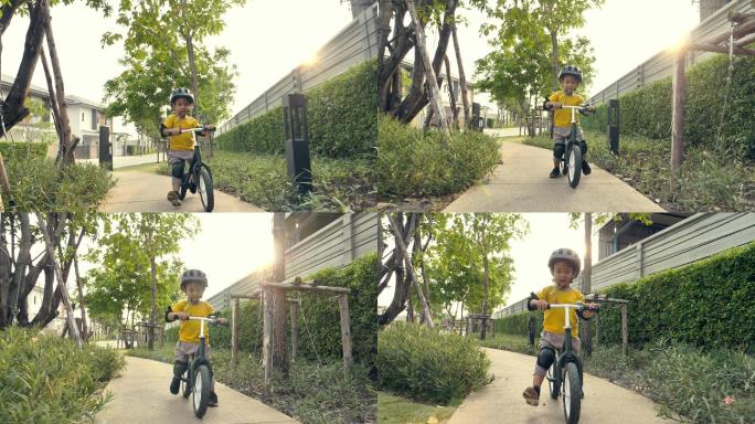 一个小男孩在公园外面骑自行车