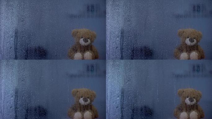 泰迪熊在孤儿院雨窗后的窗台上