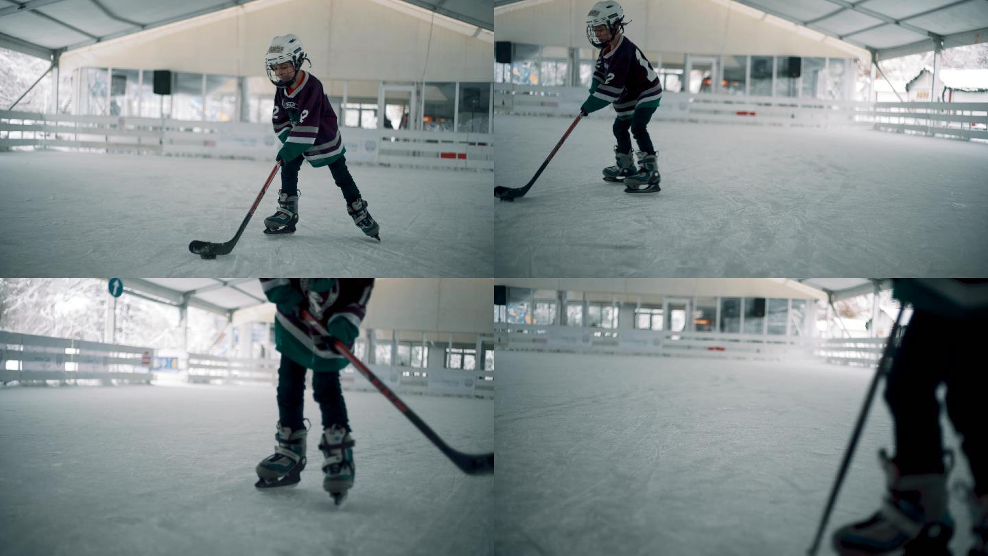 在溜冰场打冰球的小男孩