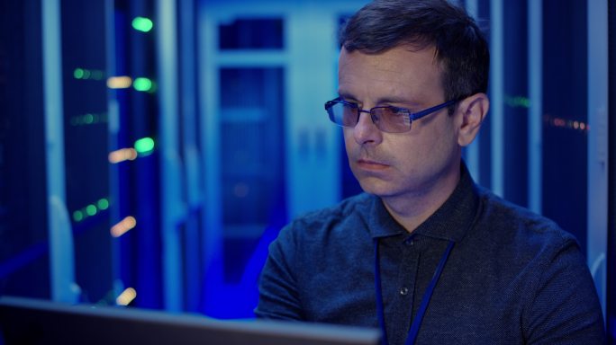 IT工程师在服务器机房使用笔记本电脑检查服务器操作