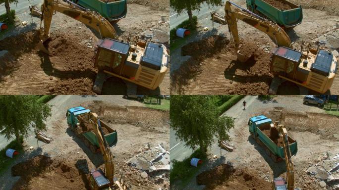 挖掘机在施工现场向卡车装载土壤。