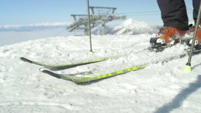 滑雪者清理滑雪板上的新鲜雪