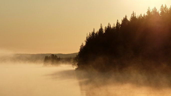日出时湖面上的晨雾