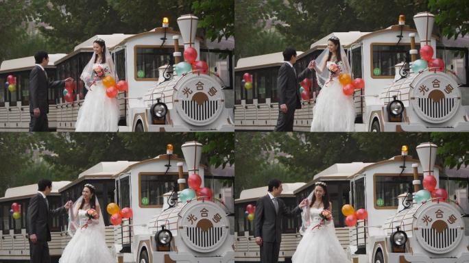 年轻情侣在小火车边拍摄婚纱照
