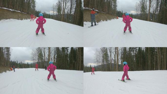 一个小女孩和滑雪教练一起滑雪下山