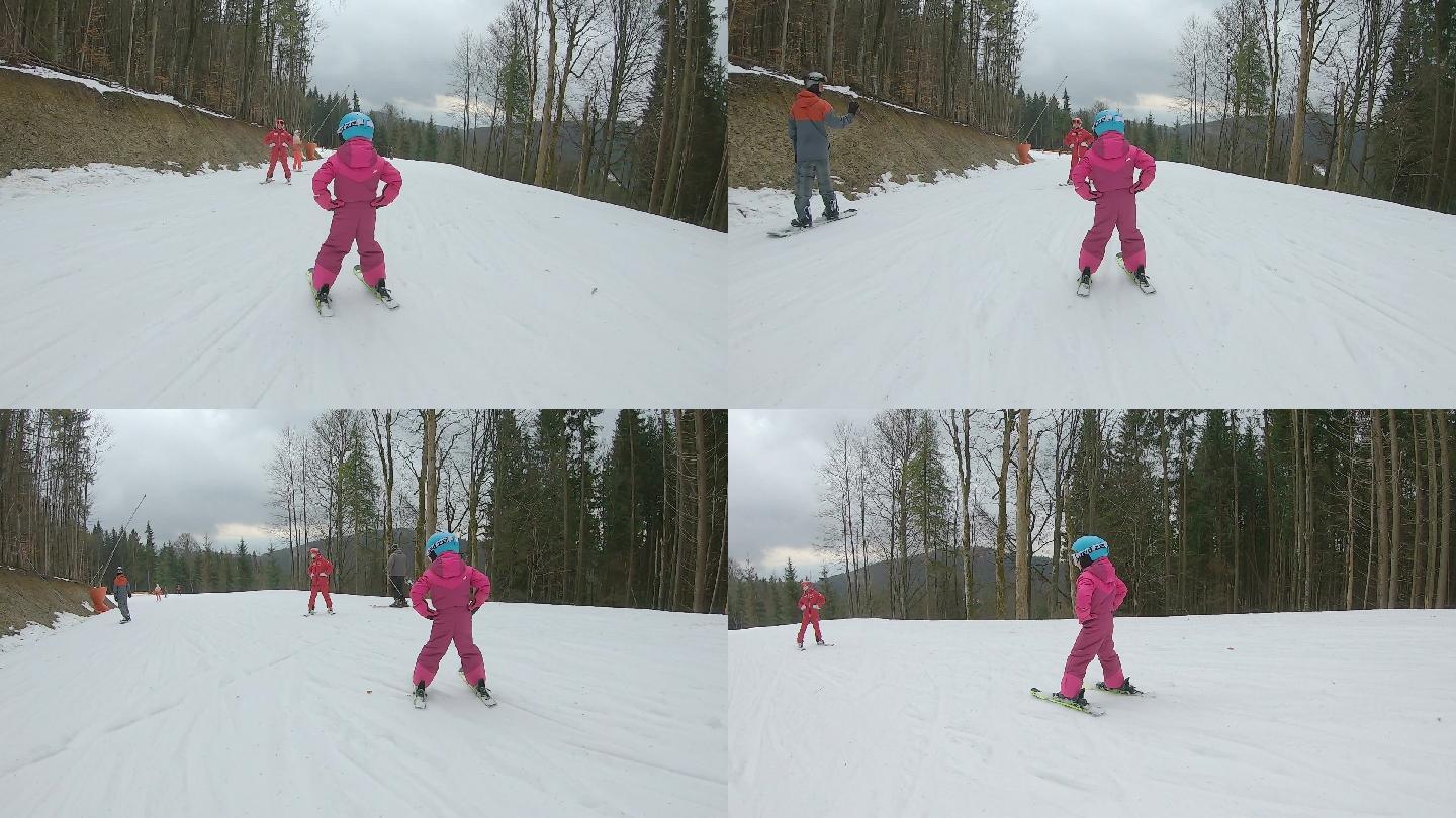 一个小女孩和滑雪教练一起滑雪下山