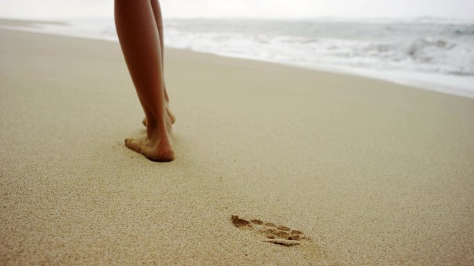 沙滩上步行的人脚步特写海边印记青春足迹