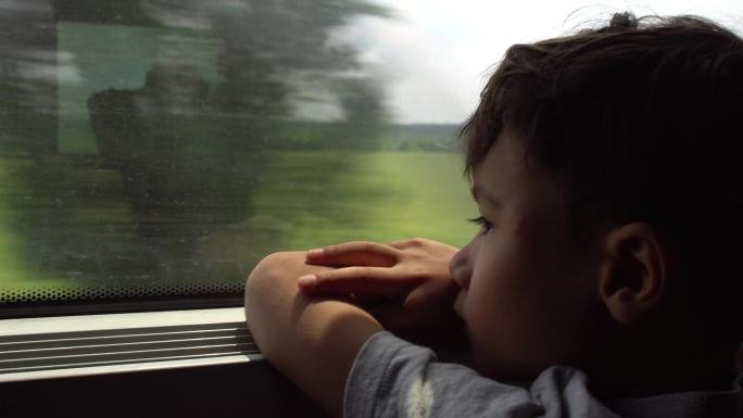 坐火车旅行的男孩车窗外离家高铁
