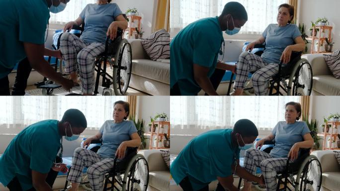 男护士在养老院轮椅上帮助老年人