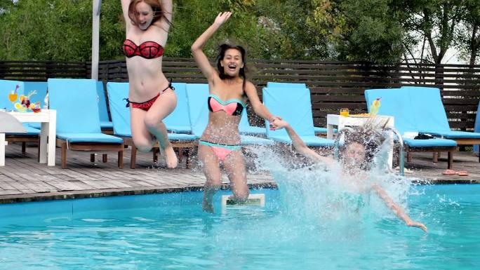 一群穿着泳衣的女孩跳进游泳池