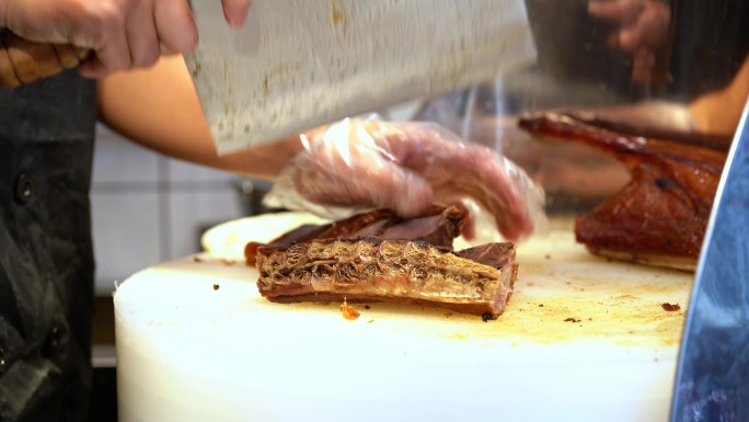广东烧腊店里的厨师在切新鲜的烧鸭，打包