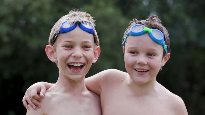 两个湿漉漉的小男孩头戴泳镜