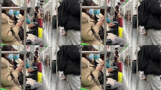 戴口罩坐地铁沉醉式玩手机的低头族人群