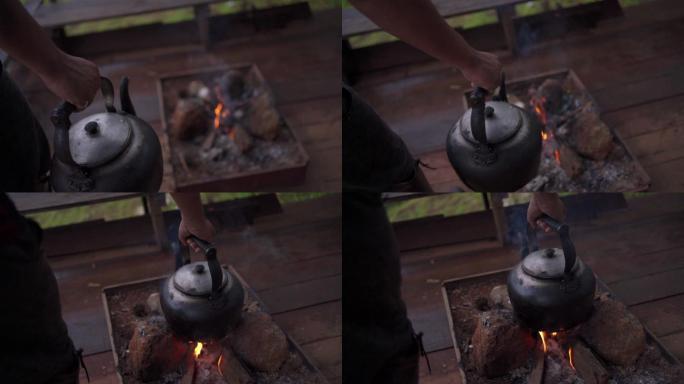 慢镜头特写镜头：男人把水壶放在篝火上