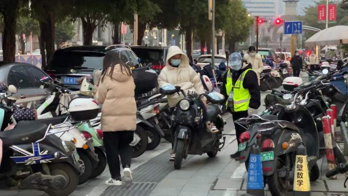 南宁金湖路电动车停放处管理员协助车主推车