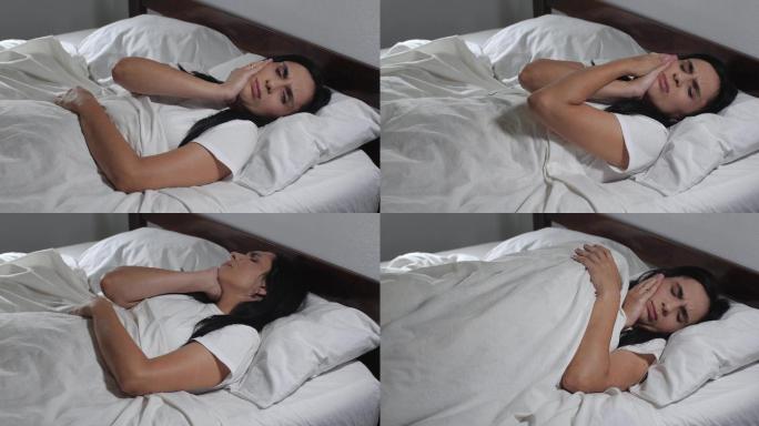 一名女性躺在床上忍受着牙痛
