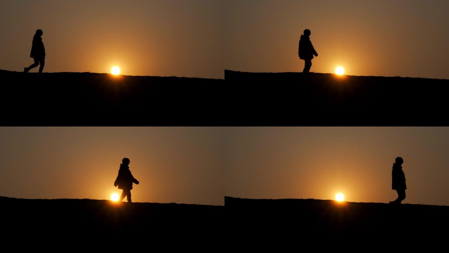 女孩剪影行走在夕阳下