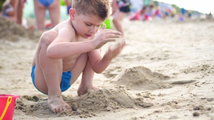 在沙滩上玩沙子的孩子