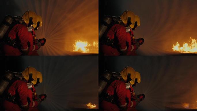 两名消防员手持灭火喷嘴灭火