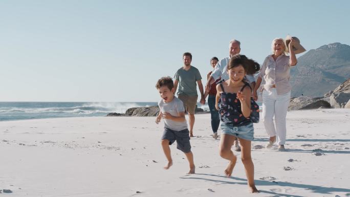 家庭成员在暑假沿着沙滩散步