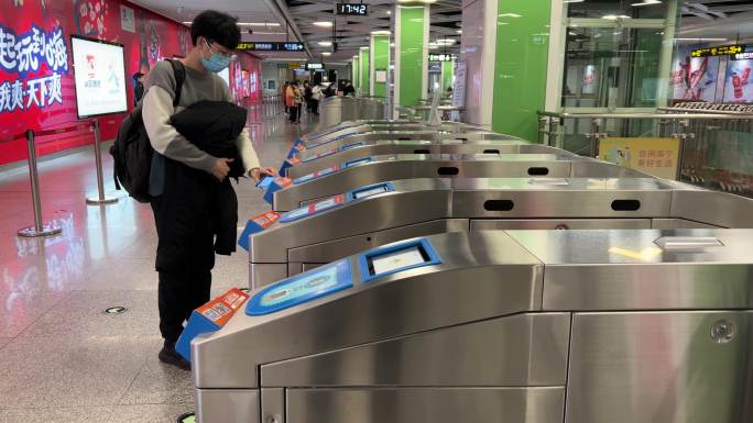地铁站年青人刷二维码通过智能翼闸乘坐地铁