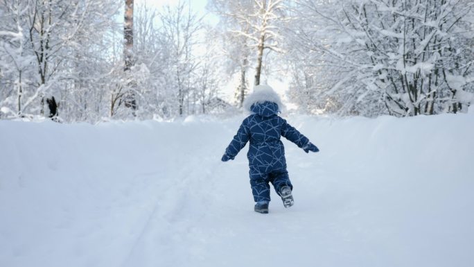 在雪地上奔跑的小男孩