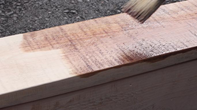 用刷子在木制品上涂保护涂层。