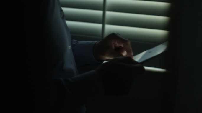 男人在黑暗中使用平板电脑