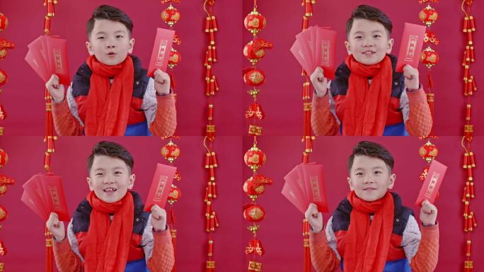 春节期间小男孩在红色背景前给大家拜年