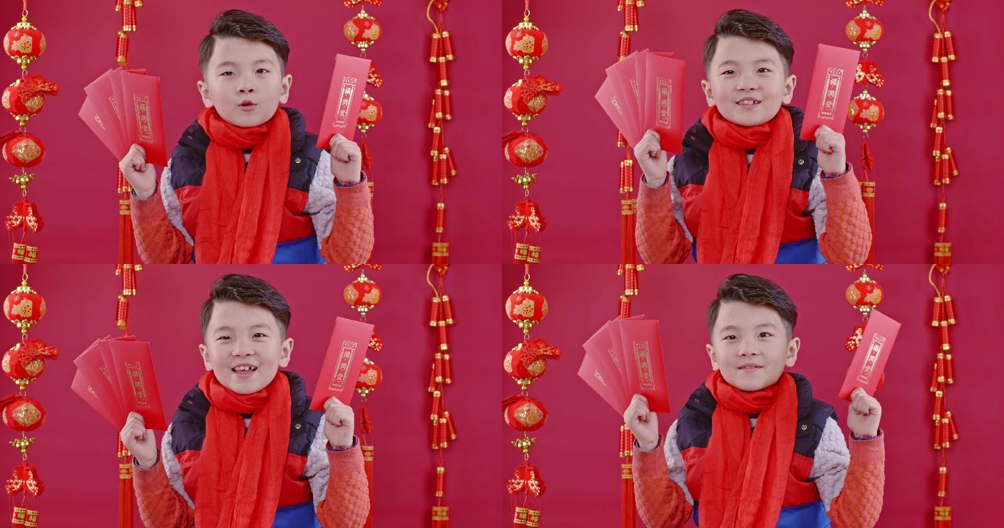 春节期间小男孩在红色背景前给大家拜年