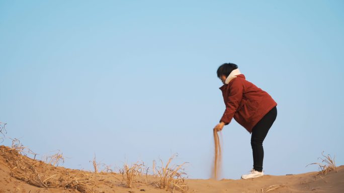 女孩手捧沙抛向天空