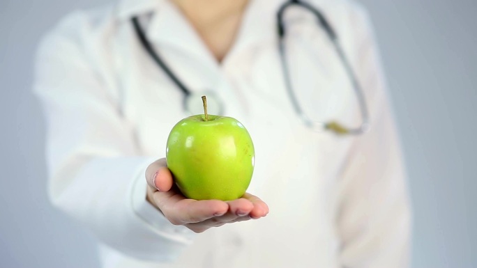 营养学家拿着新鲜的青苹果